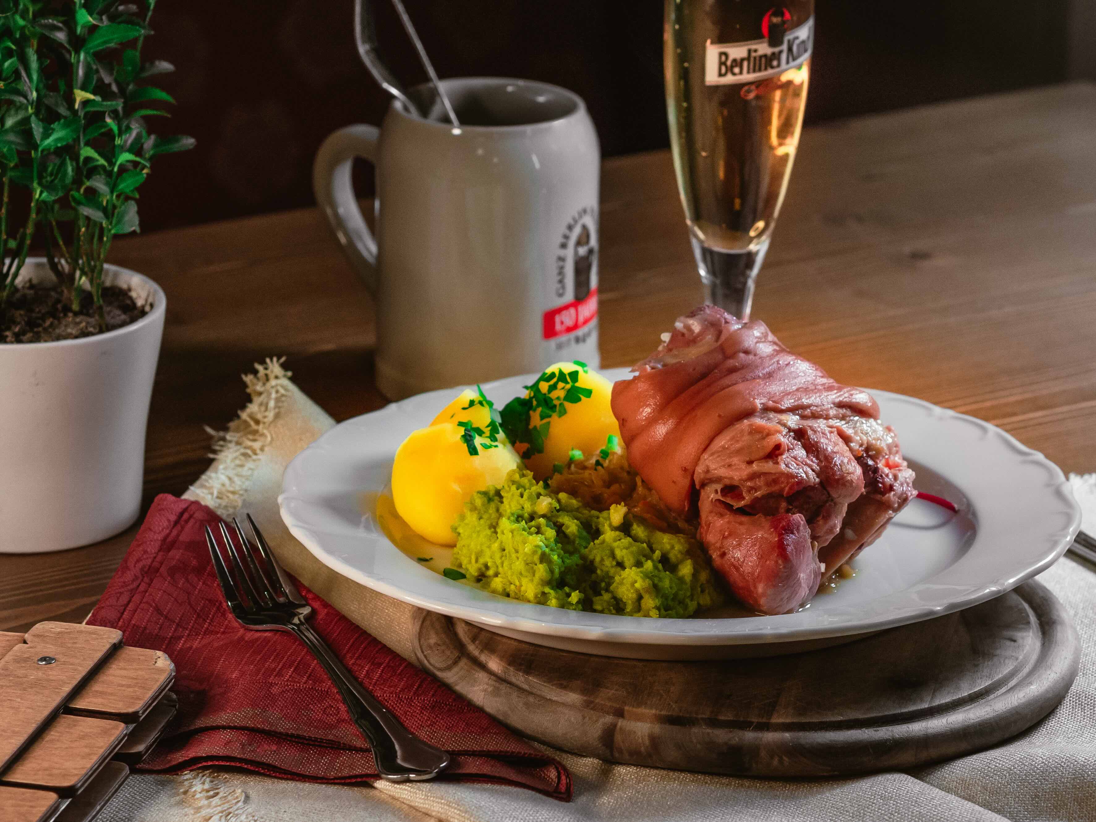 Berliner Eisbein im Wurzelsud mit Erbspüree, Sauerkraut und Salzkartoffeln, dazu ein Berliner Kindl Pils