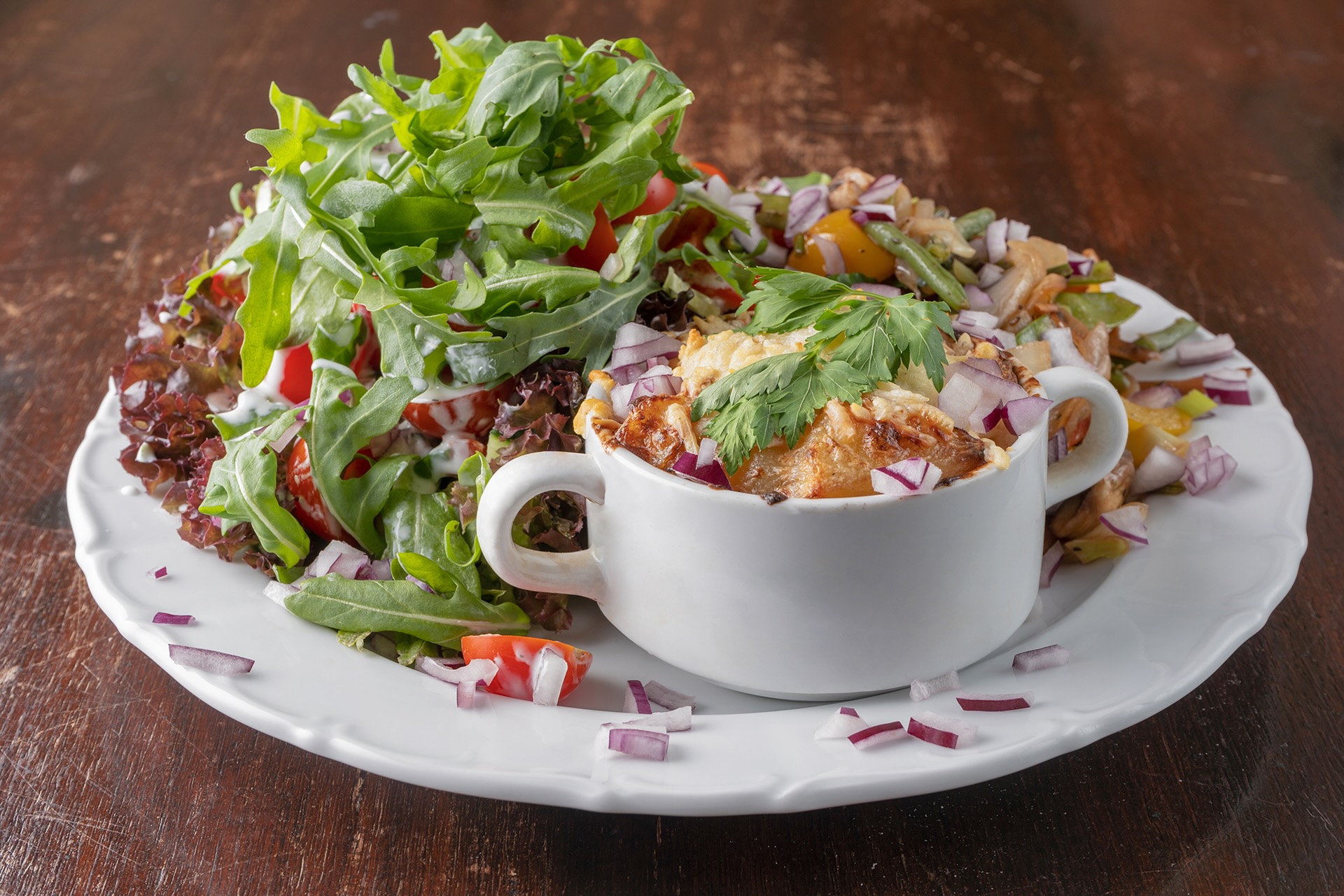 Überbackene Kartoffel mit frischem Salat auf dunklem Holztisch