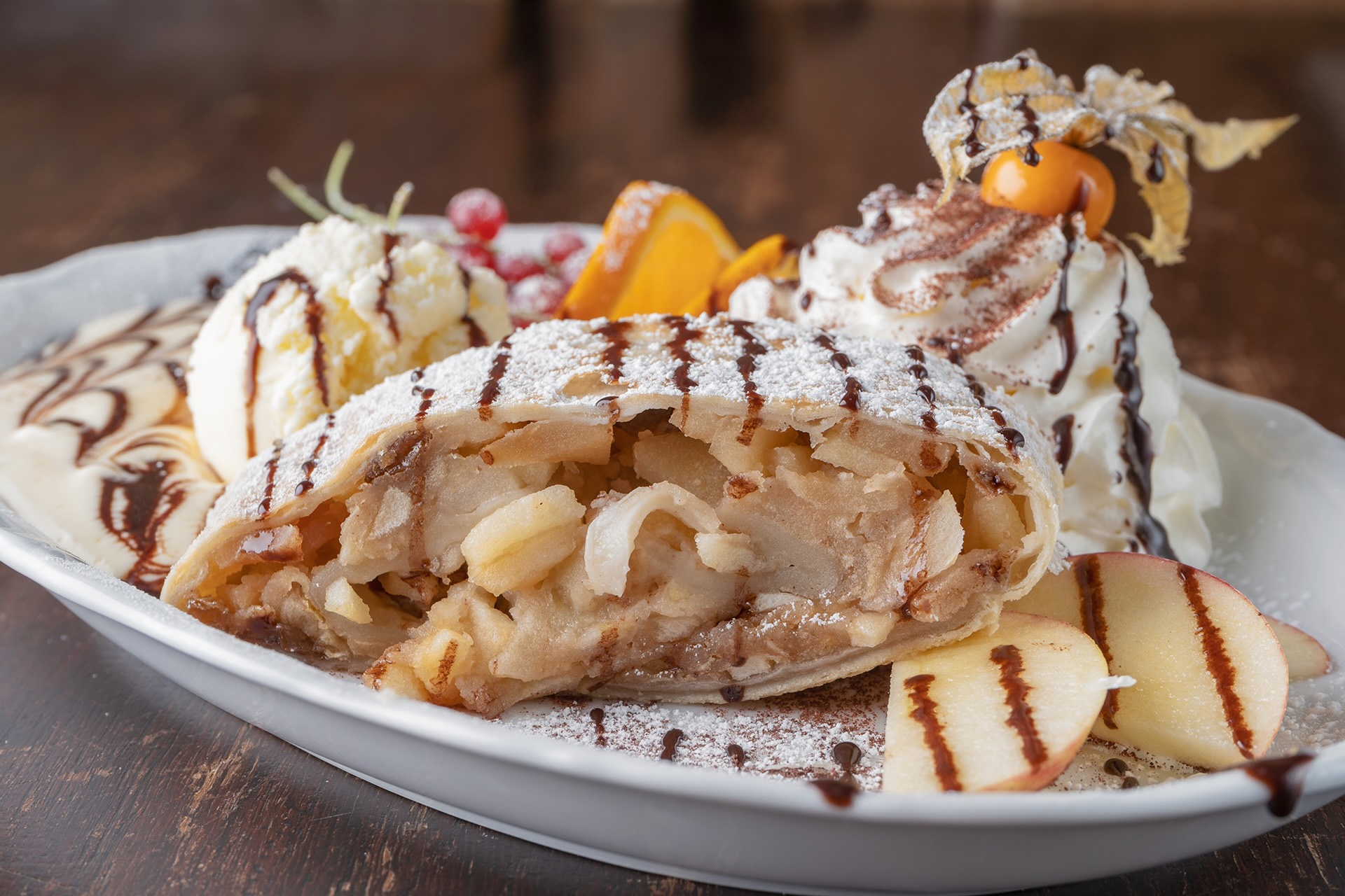 Warmer Apfelstrudel nach Art des Hauses mit Vanilleeis und Sahne